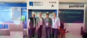 Representantes de Puntored en el México Business Forum 2025 junto a póster del evento sobre finanzas embebidas
